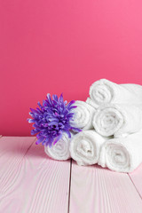 clean soft towels with flower on wooden table