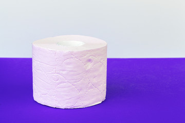 Toilet paper rolls isolated on white table with purple background
