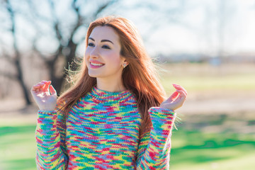 Spring time concept. Redhead woman in rainbow wool sweater, casual fashionable cloth for lady 