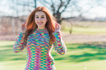 Spring time concept. Redhead woman in rainbow wool sweater, casual fashionable cloth for lady 