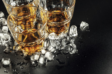 Whiskey and ice on rustic wood background