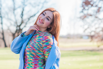 Spring time concept. Redhead woman in coat lavender color rainbow wool sweater, casual fashionable cloth for lady 