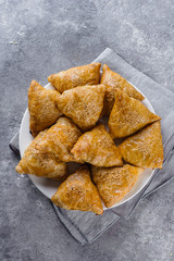 Plate with delicious samosas samsa with meat on gray background, top view. Uzbek food