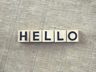 Fototapeta premium HELLO written on wooden blocks and arranged on a wooden table.