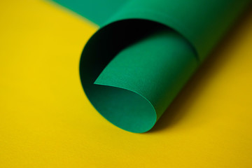 The bright green sheet paper on a yellow background. Monochrome color paper design.