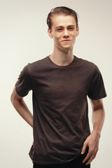 Obraz premium Isolated portrait handsome male. laughing at joke, he couldn't stop laughing. Funny friendly smiling broadly. Dressed in casual t-shirt looking at camera and standing indoors against background.