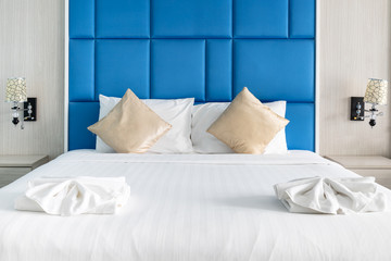Fototapeta na wymiar Bed and couple pillows in modern bedroom decorate with blue color tone