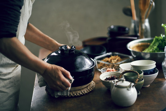 土鍋で炊いたご飯を運ぶ女性
