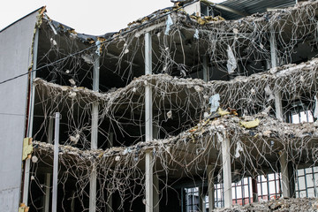 Demolish of an old house. Hydraulic excavator destroys a building