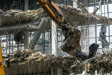 Demolish of an old house. Hydraulic excavator destroys a building