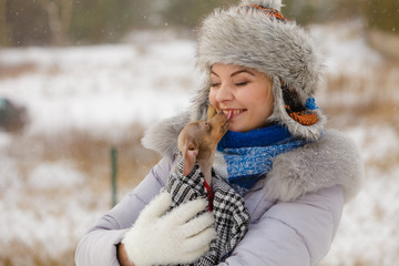 Woman hug warming her little dog in winter