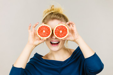 Happy smiling woman holding red grapefruit