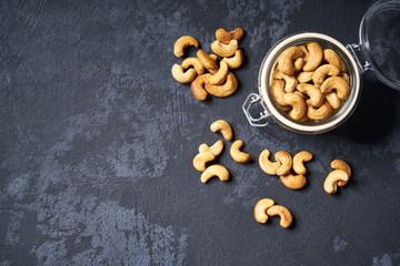 Organic cashew nuts   in a glass jar on an black table. with copy space ,Top view