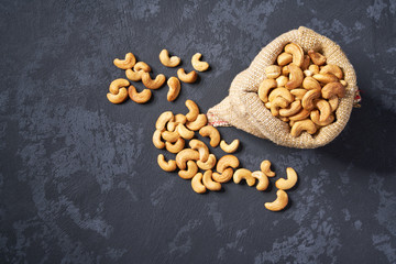 Cashew nuts in burlap bag on black background  with copy space.Top view