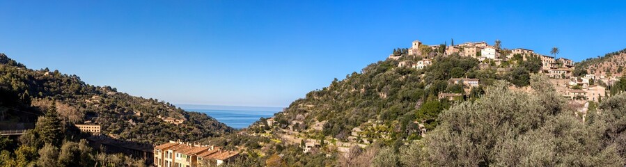 Fototapeta na wymiar Panoramic view of the artists village Deia on a sunny day with blue sky - Mallorca, Balearic Islands, Spain, Europe