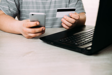 Cropped picture of man with credit card white pattern and phone