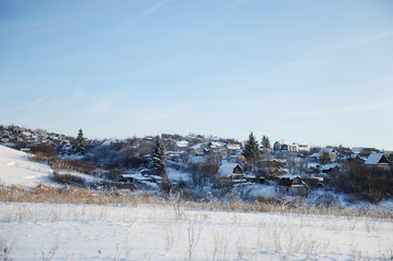 Fototapeta na wymiar Winter snow landscape. Winter Russian village. Houses and trees. Bright blue sky
