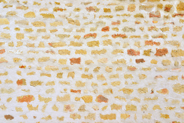 Mur de pierres jaunes et orangées incrustées avec enduit blanc