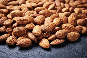 almond nuts on black table , selective focus