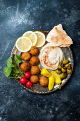 Middle Eastern meze platter with falafel, pita,  hummus, pickles, radishes. Mediterranean or greek appetizer party idea