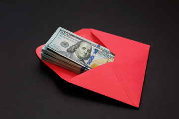Dollar money in the red envelope on black background bonus, reward, benefits concept.