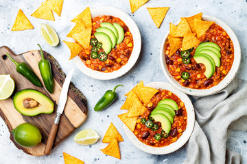 Vegetarian chili con carne with lentils, beans, nachos, lime, jalapeno. Mexican traditional dish