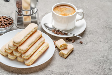 Italian Savoiardi ladyfingers Biscuits and cup of coffee on concrete backgound