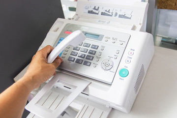 hand man are using a fax machine in the office. Business concept 