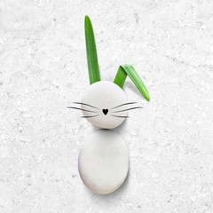 Bunny with sea stones on a marble background. Creative Easter greeting card. Top view. Copy space. Mock-up