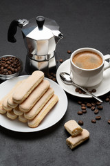 Italian Savoiardi ladyfingers Biscuits and cup of coffee on concrete backgound