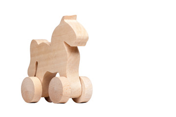 Minimalistic small wooden horse figure design on wheels, concept of trojan horse and mischief or simple child's toy isolated on white