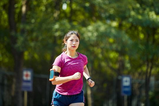 young asian female athlete running outdoors