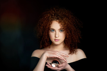 A girl with lush curly red hair. Holds in his hands a glass globe. Mystery,a premonition of the future.