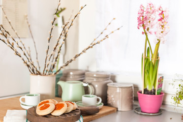 Still life with homemade cookies with jam and fresh coffee on the table near with flowers. Breakfast in the interior of the kitchen at home. Lifestyle, vintage photo.