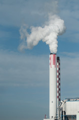 Fototapeta na wymiar closeup of white smoke of chemical factory chimney on blue sky background