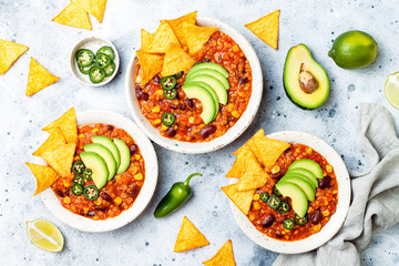 Vegetarian chili con carne with lentils, beans, nachos, lime, jalapeno. Mexican traditional dish