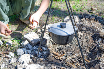 Cooking on a fire at spring. Close view of caldron over the campfire.