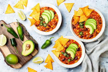 Vegetarian chili con carne with lentils, beans, nachos, lime, jalapeno. Mexican traditional dish