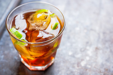 Cuba libre cocktail with cola and lime. Selective focus.
