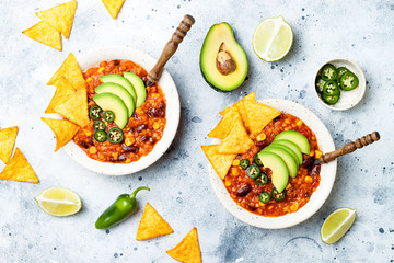 Vegetarian chili con carne with lentils, beans, nachos, lime, jalapeno. Mexican traditional dish