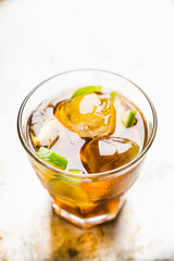 Cuba libre cocktail with cola and lime. Selective focus.