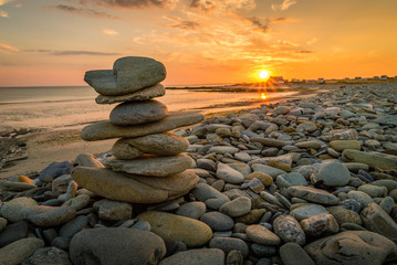Pile of rocks kern on a beach in Penhors, Brittany, France, at sunset