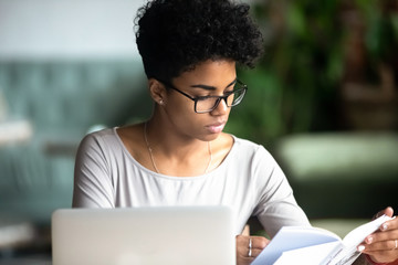 Concentrated african beautiful woman studying reading a book