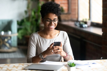 Black woman sitting at table take a break surfing internet