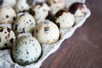 Fototapeta premium Textured spring background with small quail eggs. Eco products. Quail eggs in cardboard packaging