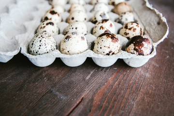 Textured spring background with small quail eggs. Eco products. Quail eggs in cardboard packaging