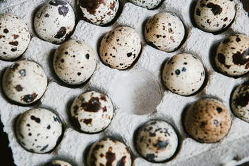 Textured spring background with small quail eggs. Eco products. Quail eggs in cardboard packaging