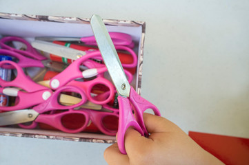Hand with start children safety scissors and box