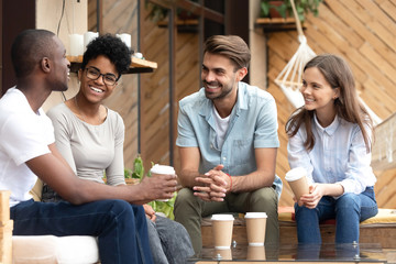 Positive friends talking sitting in coffee shop