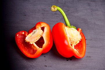 sweet red pepper and half cut isolated on black